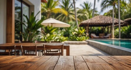 Empty wood table top on a tropical home terrace setting with a blurred background. The focus is on the table surface.