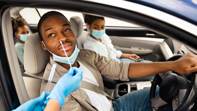African American Man Getting Tested For Coronavirus In Car, Driving Traveling With Family By Auto. Unrecognizable Medical Worker Making PCR Test For Male Driver. Covid-19 Pandemic Concept - Powered by Adobe
