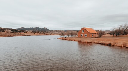 Obraz premium Serene Mountain Lake Surrounded by Fir Trees and a Picturesque Red House