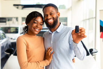 Happy Car Owners. Portrait Of Young Black Couple With Automobile Keys In Hands Posing In Modern...