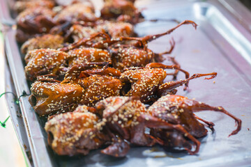 Grilled bird, grilled quail, sold at a street market in Thailand, street food
