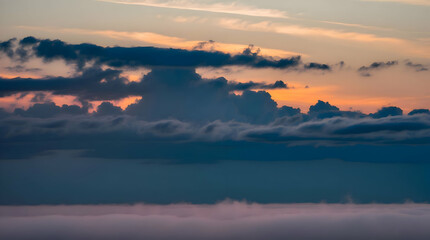 Obraz premium Dramatic sunset cloudscape over a misty horizon.