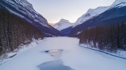 Majestic Winter Landscape View of Frozen Lake Surrounded by Snow-Capped Mountains and Evergreen Trees at Dusk in a Remote Wilderness Area