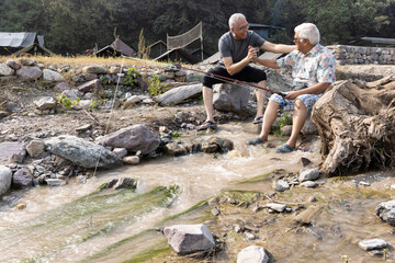 Week-ed activities between senior friends. Fishing on the river, at sunset.
