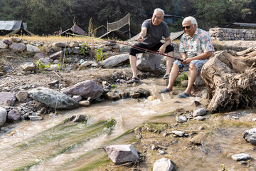 Week-ed activities between senior friends. Fishing on the river, at sunset.