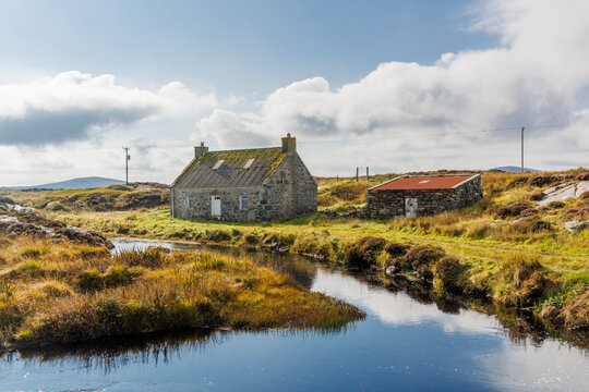 Scotland, Hebrides. Isle of North Uist. Traditional stone house by a stream. Moorland.