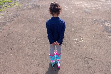 Rear view of a little girl playing roller skates