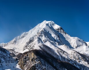 Snow-Capped Peak: A majestic snow-capped mountain peak dominates the horizon under a clear blue sky.  Its slopes, covered in pristine white snow, seem to rise to the heavens.