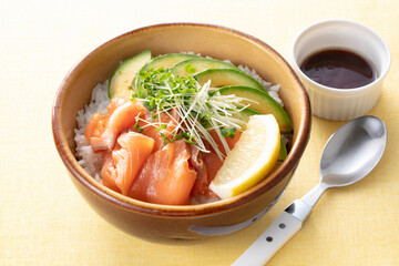 Hawaiian poke bowl with salmon avocado and rice served in bowl