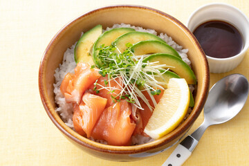 Hawaiian poke bowl with salmon avocado and rice served in bowl