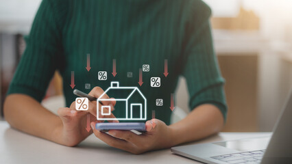 Women use smartphones with virtual home icons and down arrow for economical real estate and lower...