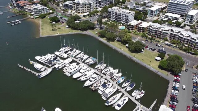 4K Aerial view of a boat harbour flying towards high rise holiday apartments on Australia's Sunshine Coast