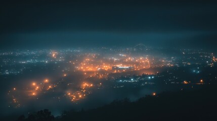 Naklejka premium Night Lights Cityscape: A Misty Mountaintop View