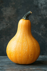 A Single Pale Orange Gourd Rests On Dark Wood