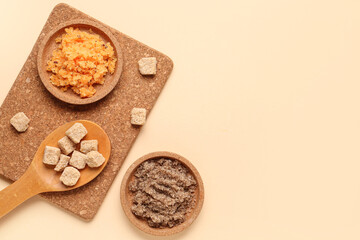 Composition with plates of body scrub and cane sugar on color background