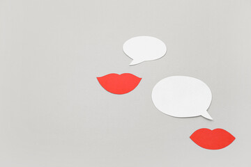 Paper lips with speech bubbles on grey background. Dialogue concept