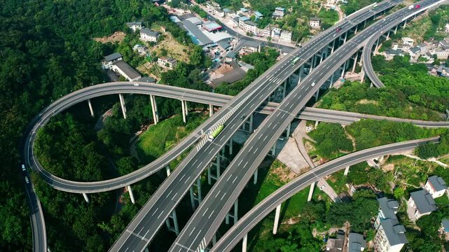 Aerial view of busy atmospheric highway with moving vehicles surrounded by lush greenery