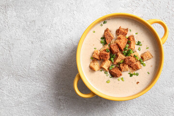 Pot of tasty cream soup with croutons on grey background