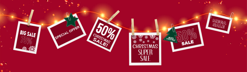 Christmas sale tags hanging on bright glowing garland with wooden and paper clips on red background with confetti. Holiday discount cards decorated with snowflakes, star, tree offering special deals.