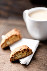 Cantuccini (Italian cookie) and a cup of coffee on dark wooden background. Close up.