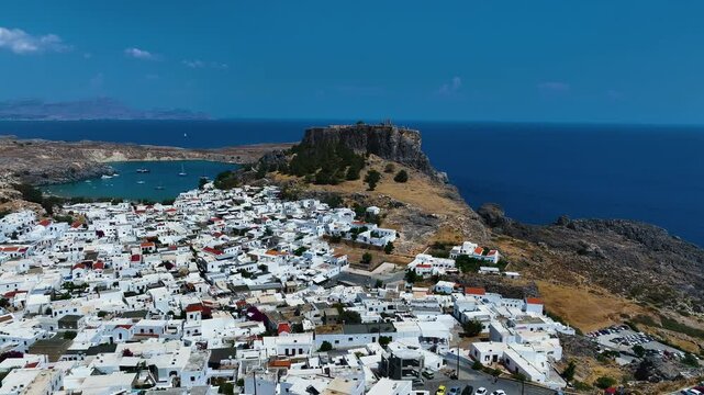 Drone flying toward the Acropolis of Lindos, sunny day in Rhodes, Greece