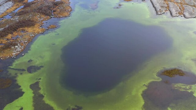Aerial shot revealing a large black spot at the bottom of a seasonal lake in Burren's groundwater network. County Clare