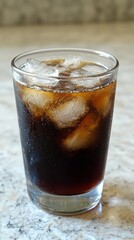 A refreshing glass of Vietnamese c ph sa iced coffee sits on a smooth marble surface, filled with ice cubes and rich, dark brew. Perfect for savoring on a warm day while relaxing