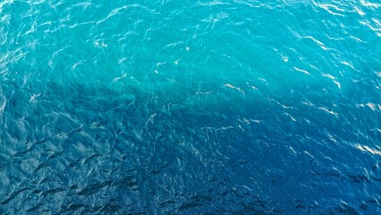 A close up on the blue of the Atlantic Ocean. The texture of the blue water of the sea. background, close up, top view.