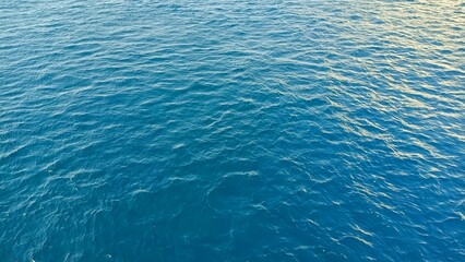 A close up on the blue of the Atlantic Ocean. The texture of the blue water of the sea. background, close up, top view.