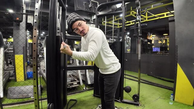 Young Man Performing Cable Triceps Pushdowns in the Gym, with a Background of Machines and Stunning Lighting, Captured in Slow Motion