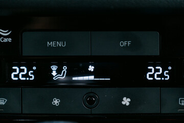 Car climate control panel displaying temperature and settings