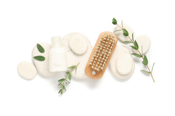 Composition with massage brush, cosmetic product, spa stones and eucalyptus branches on white background