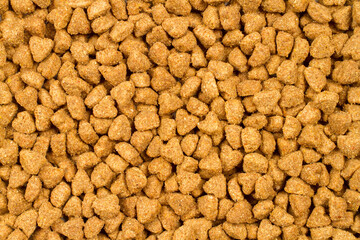 Texture of dry pet food. Brown cat food pellets.