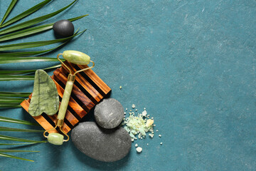 Obraz na płótnie Canvas Composition with facial massage tools, sea salt, spa stones and palm leaf on color background