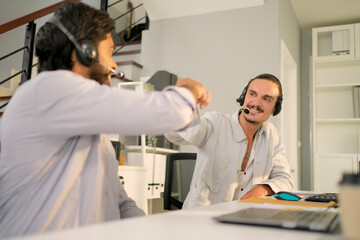 Fist bump collide agreement of two businessman, show strength teamwork, handshake negotiations finish together after good deal. Customer support operator with hands-free headset working in the office.