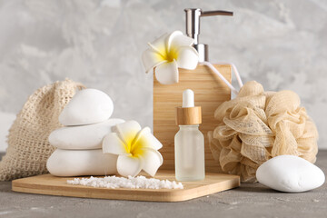 Composition with cosmetic products, spa accessories and tropical flowers on grunge background