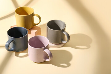 Set of different ceramic mugs on color background