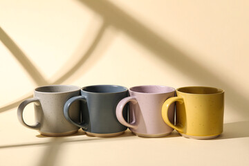 Set of stylish ceramic mugs on color background