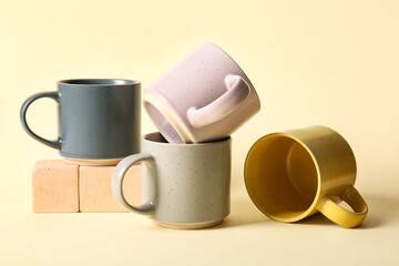 Set of stylish ceramic mugs on color background
