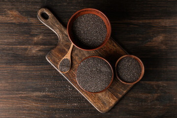 Bowls and spoon with chia seeds on wooden background