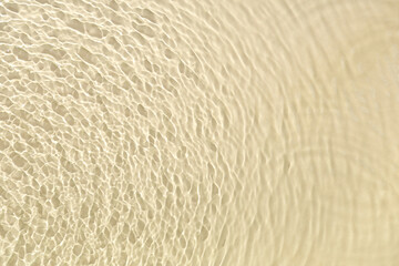 Texture of clean water with ripples on light yellow background