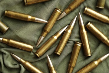 Many rifle bullets on military camo green fabric background