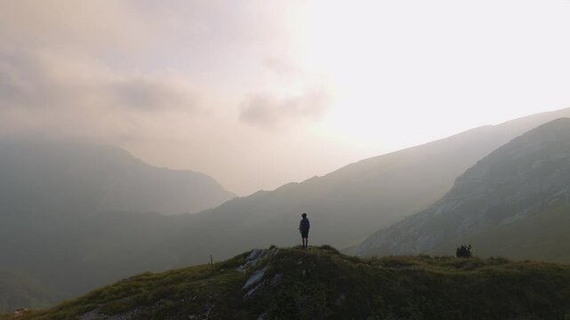 Young man standing at scenic Italian alps mountains on panoramic Monte Baldo near Lake Garda, Verona