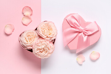Composition with gift box, rose flowers and petals on color background. Valentine's Day celebration.