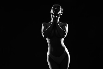 Silhouette of attractive young Asian woman on black background