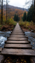 Obraz premium rustic wooden bridge crossing flowing river in autumn