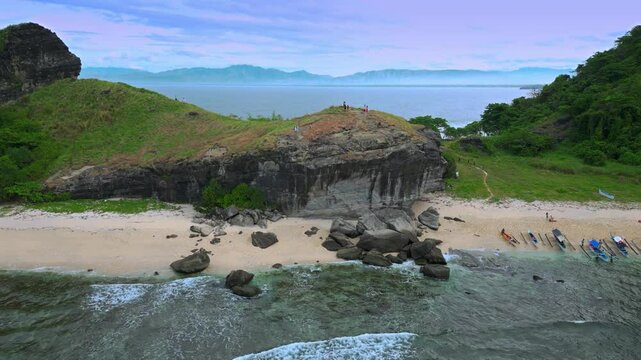 Local boats with tourists arrived at mountain range at Capones Island, Pundaquit beach. Zambales, Philippines