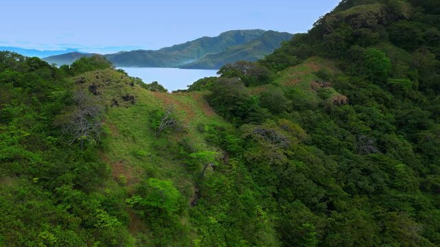 Flying on a drone above mountain range at Capones Island, Pundaquit beach. Zambales, Philippines. In the morning.