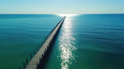 Long jetty extending toward the horizon with turquoise waters reflecting sunlight, peaceful seascape