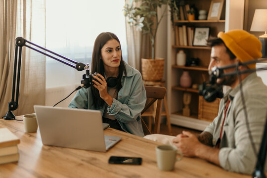Engaged and expressive: Co-hosts working together during a podcast recording session.